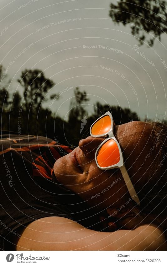 Woman with sunglasses relaxing in the evening sun Evening sun Young woman relaxation vacation holidays Relaxation Contentment fortunate Vacation & Travel Summer