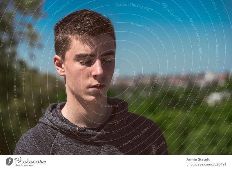 outdoor portrait of a young man with closed eyes relax sleep dream emotion expression silent beautiful teen teenager male confident caucasian standing white