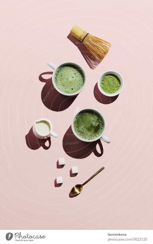 Vegan matcha latte with oat milk on pink powder whisk creamer sugar cubes cup tea japanese mug beverage drink refreshments hot healty antioxidant asian detox