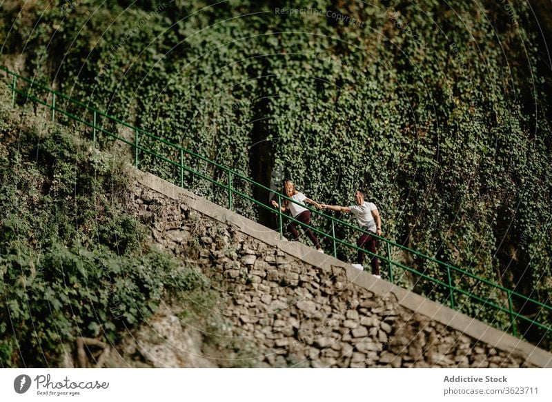 Young couple climbing stairs in nature follow active together relationship love young girlfriend boyfriend journey walk romantic romance path step stairway pull