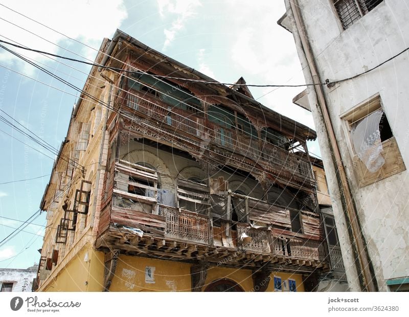 Reminder of better days of a house Facade Architecture Corner Window Weathered Sky Old town Authentic Change Transience power cable Colonial style