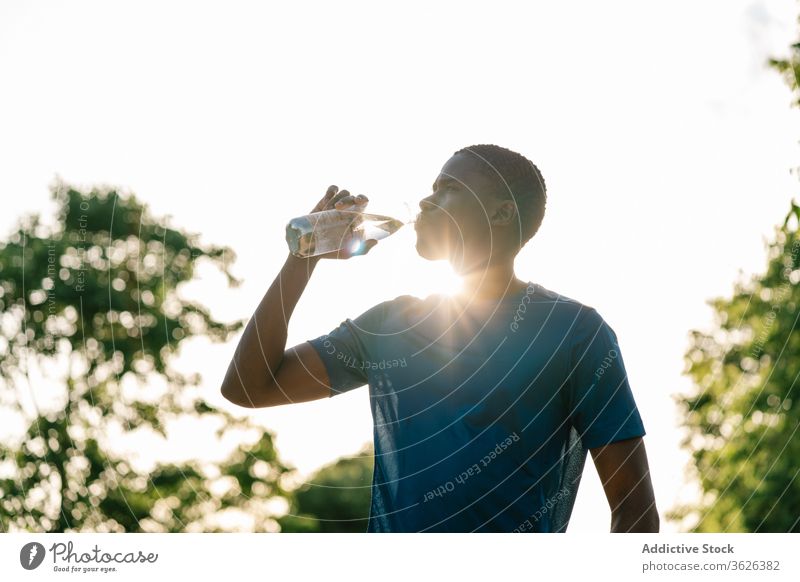 Athletic black man drinking water african fitness strong flexing body muscle biceps arms athlete strength lifestyle athletic training workout healthy young