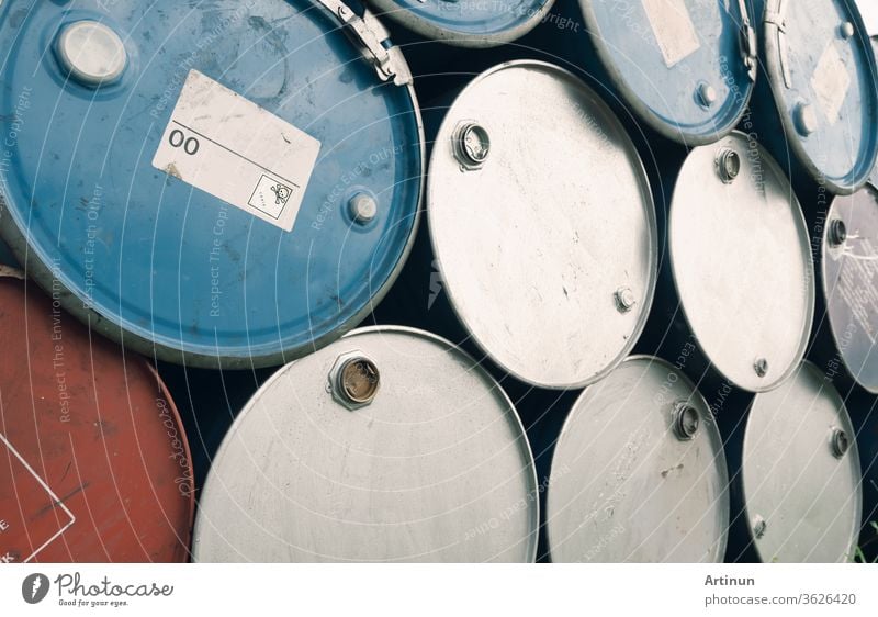 Old chemical barrels. Blue and purple oil drum. Steel oil tank. Toxic waste warehouse. Hazard chemical barrel with warning label. Industrial waste in metal drum. Hazard waste storage in factory.