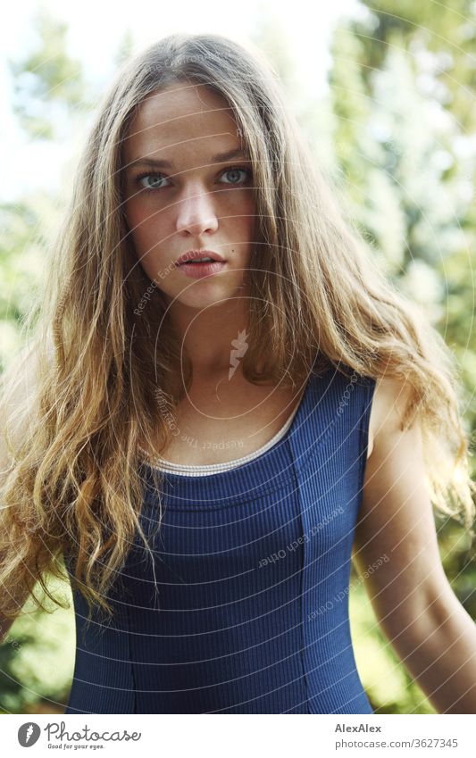 Portrait of a young woman on the balcony in front of trees Blue sky huts Intensive girl Adults portrait Day Skin Sunlight Self-confident Central perspective