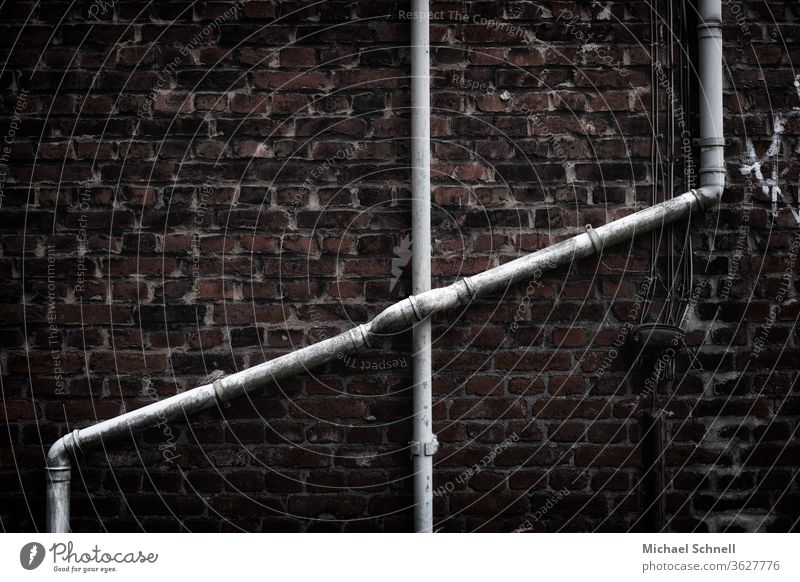 Crossing water pipes on an old brick wall of a house reeds Water pipes Transmission lines Wall (building) Deserted Wall (barrier) Metal Colour photo Old