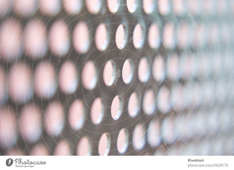 Stainless steel perforated plate with bright background, clear focus in the middle of the picture, right and left blurred Perforated plate, Hollow Metal Pattern