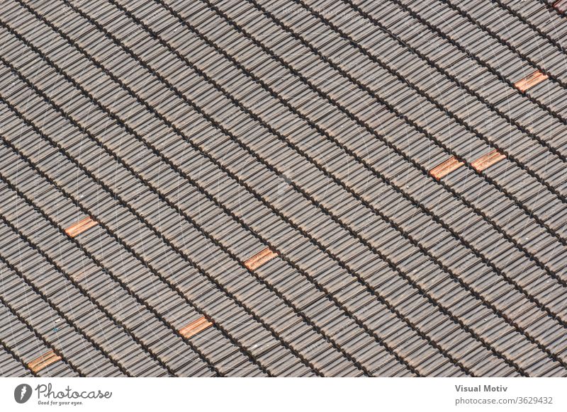 Background of traditional terracotta tiles of an old roof forming a diagonal pattern roof-tile texture building ceramic abstract sunny background architecture