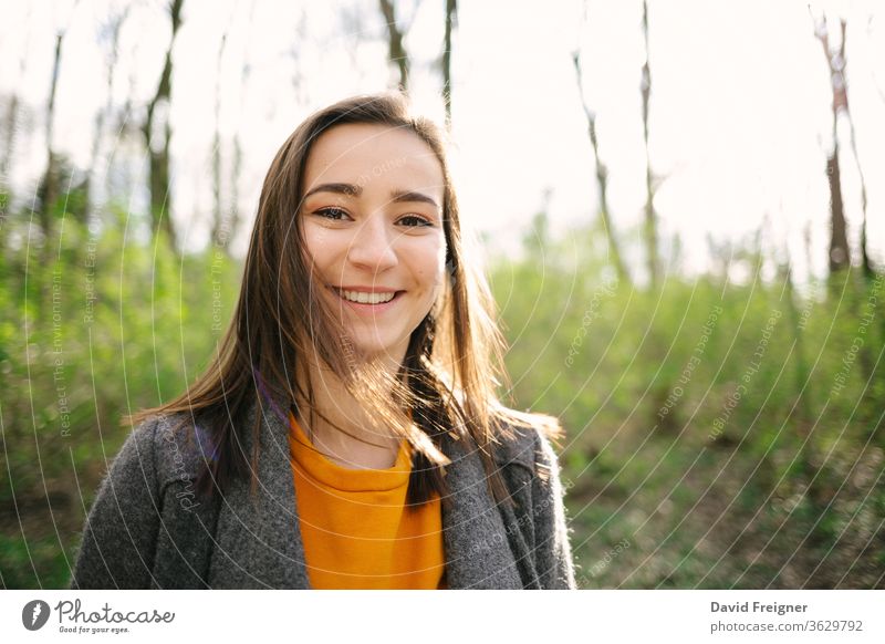 Young and attracive woman standing and laughing in the woods. Lifestyle,health and enviromental protection concept. Vintage analog film look. beautiful windy