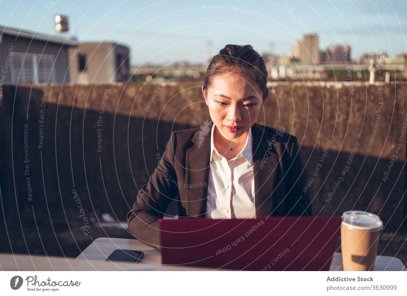 Busy woman with laptop working on rooftop using businesswoman formal device gadget asian young female internet communicate browsing connection entrepreneur