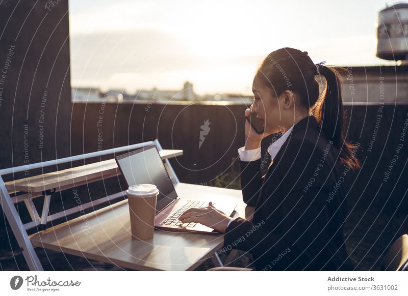 Busy woman with laptop working on rooftop smartphone using talk businesswoman formal device gadget asian young female internet communicate browsing connection