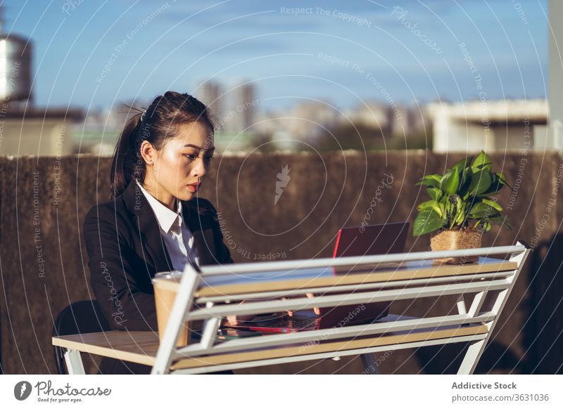 Busy woman with laptop working on rooftop using businesswoman formal device gadget asian young female internet communicate browsing connection entrepreneur