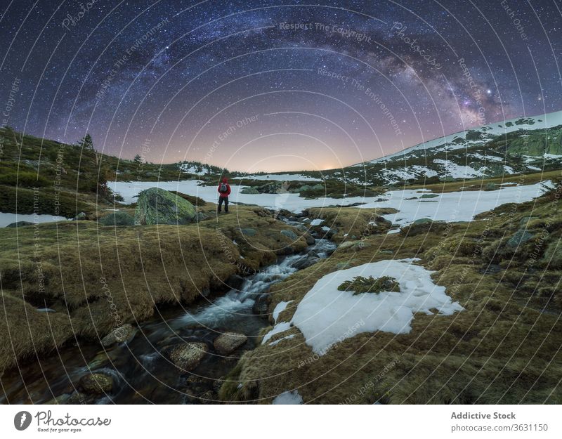 Traveler admiring view of Milky Way in mountainous terrain milky way traveler landscape sky twilight nature rough wild slope galaxy spectacular snow scenery