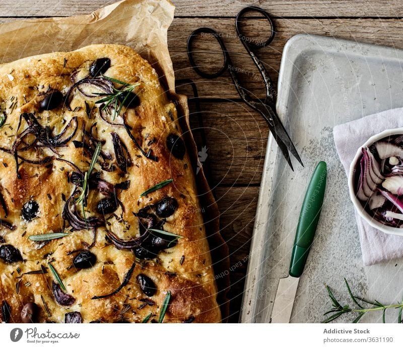 Focaccia with black olives and herbs on wooden table focaccia bread yeast italian bread ingredient handmade onions cooking italian focaccia with herbs