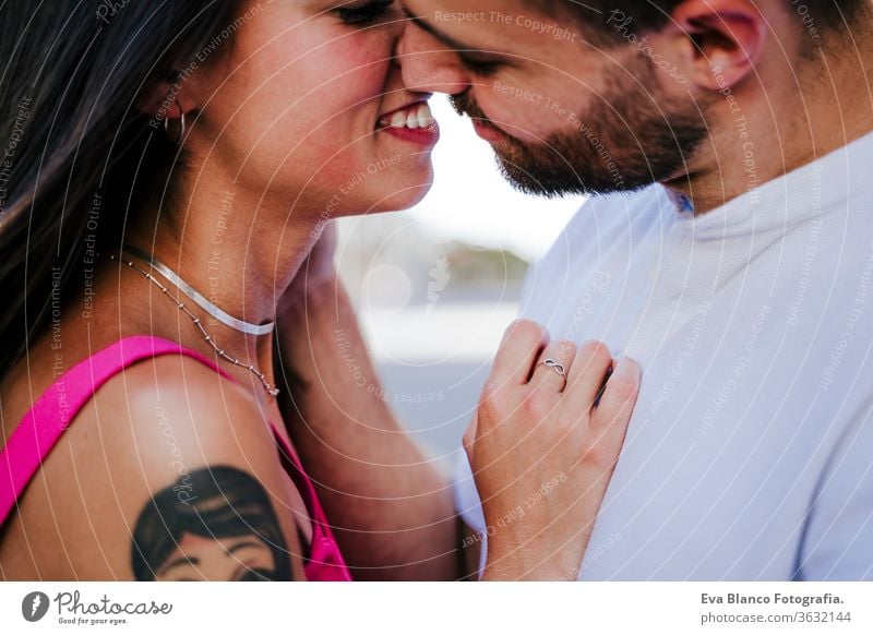 close up of happy young couple in love in the city. Family and lifestyle concept man woman together togetherness daytime hug kiss people smiling girl urban