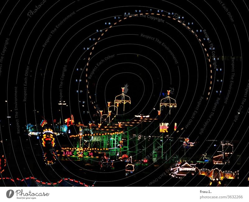 The hustle and bustle in Hamburg, the cathedral, sends colourful light into the night sky. Fairs & Carnivals Showman stalls Carousel Night Ferris wheel