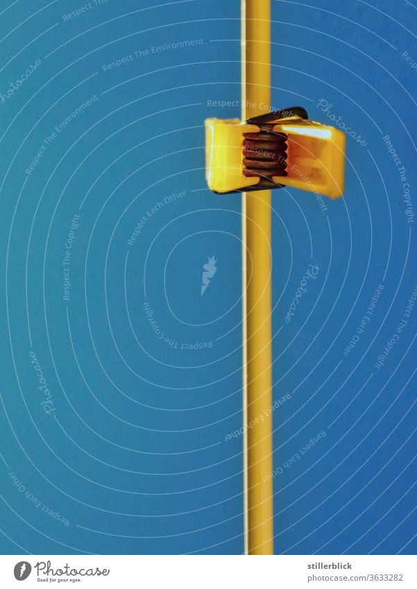 yellow clothespin on the line, photographed from below, in front of a blue sky Clothesline Holder Household hang yellow blue Exterior shot Colour photo