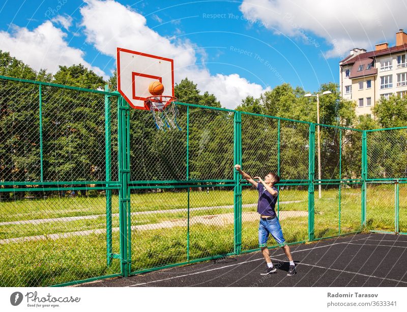 young man playing basketball outdoor on bright sunny summer day street people urban city person adult lifestyle happy male outdoors leisure caucasian portrait