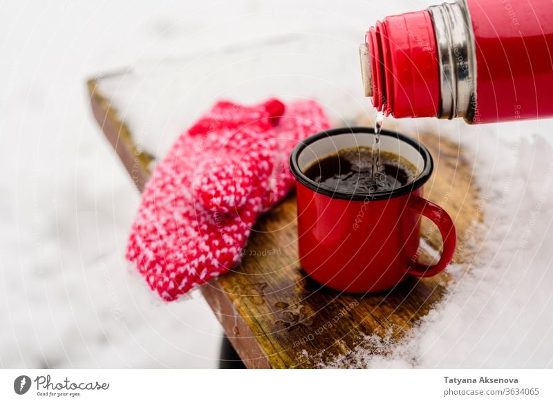 Red cup with hot coffee or tea drinking on snow in winter Hot Winter Mug Cup Snow Coffee Drinking chill mittens warm Christmas Tea Public Holiday White Beverage