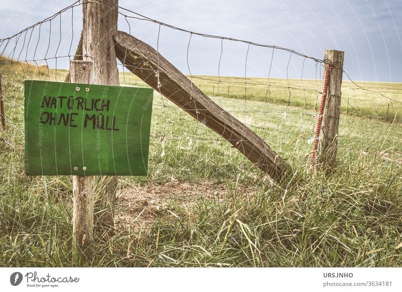 green sign with the inscription NATURALLY WITHOUT WASTE on a pasture fence Meadow Willow tree Fence Signs and labeling Signage Characters Typography leap