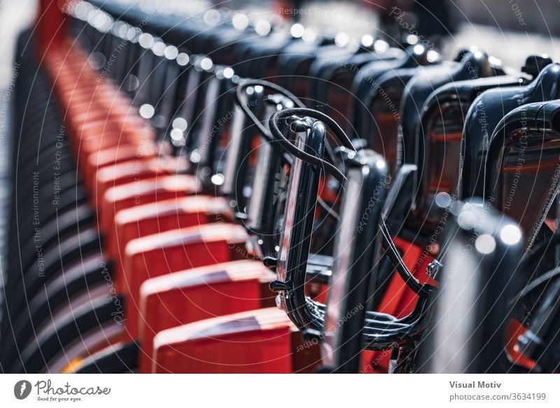 Abstract detail of a row of modern rental bicycles parked on a city street parking sunny daytime urban transport town exterior contemporary vehicle public bike