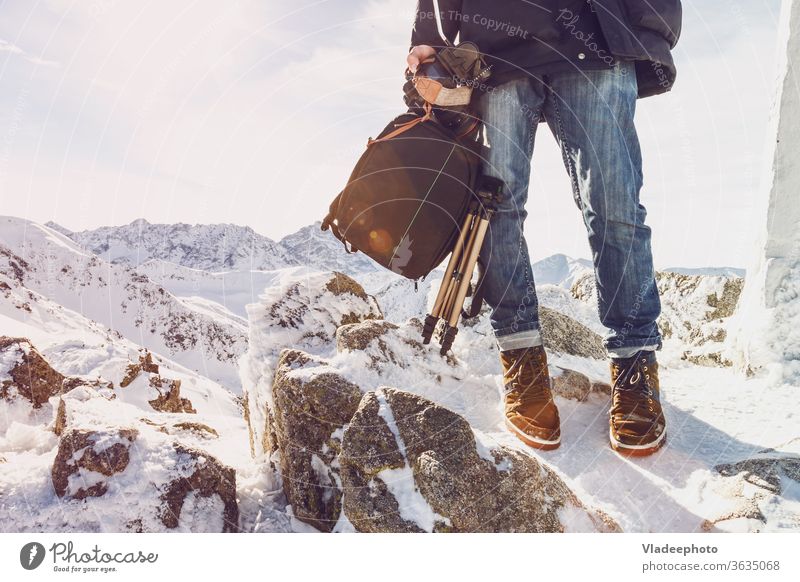 Photographer traveler on a mountain top with equipment in hands photographer blogger man leg foot rocks range freedom independence courage fashion lifestyle