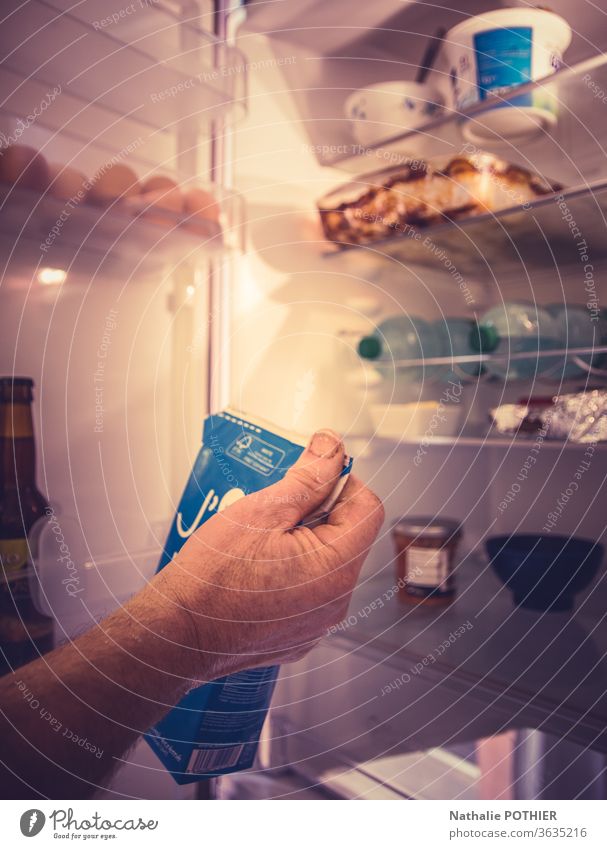 Man taking milk box from the fridge refrigerator Close-up Light Food Beverage box Hand Dairy Products Open Opening man Milk bottle milk can Healthy Colour photo