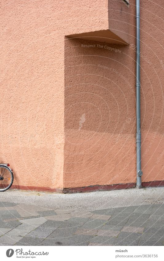 House corner with bicycle and drain pipe House (Residential Structure) Corner Bicycle conduit slabs Pink Gray Brown Triangle Colour void question shade shelter