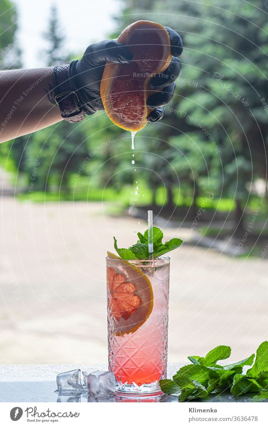 A refreshing summer cocktail with a slice of grapefruit. Alcoholic drink Paloma. Decorated with a sprig of mint and ice cubes. alcohol aperitif heat crush drops