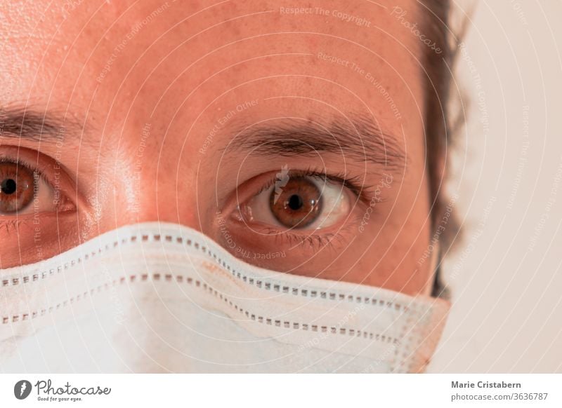 Close up of an overworked male nurse wearing a surgical mask Male nurse Caucasian male Eyes wide open Covid-19 pandemic Essential worker Healthcare professional