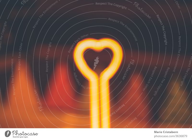 Heart shape neon light that is blurred on purpose to show concept of love, social distancing, self isolation and mental health during the quarantine due to the covid-19 outbreak