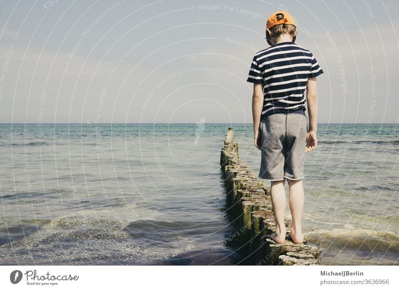 Boy at the Baltic Sea stands on bollards Ocean Boy (child) Schoolboy Child children holidays vacation East Germany Rostock Warnemünde pollster Balance Joy fun