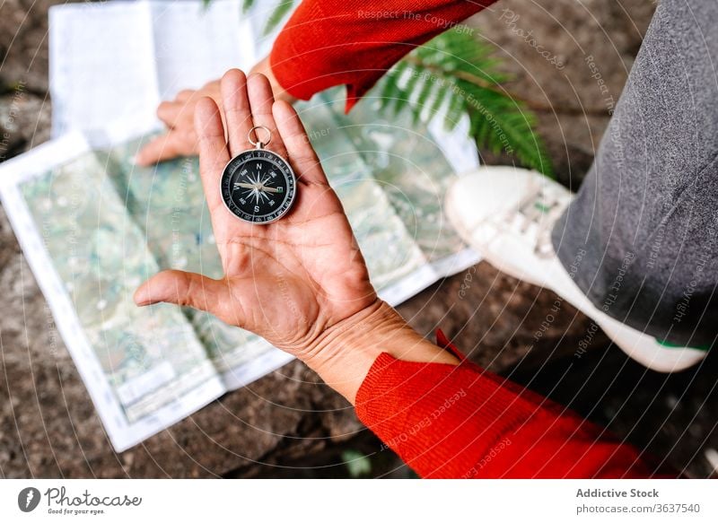 Crop elderly woman navigating with compass and map navigate orientate traveler forest read tourist female adventure trip vacation tourism rock explore journey