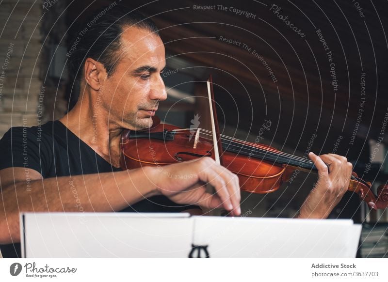 Ethnic male musician playing violin instrument man talent sheet violinist melody ethnic hispanic perform rehearsal sound entertain tune hobby rhythm player