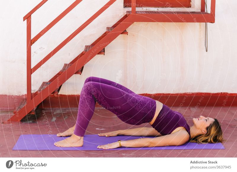 Tranquil woman practicing yoga in Bridge asana bridge pose balance activewear lying calm harmony setu bandha sarvangasana female tranquil serene meditate