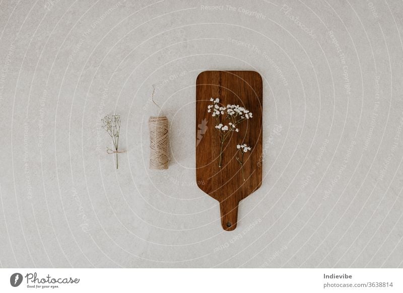 Chopping board with dried flower and string on marble background beige chopping board concept conscious consumption decoration craft decorative design diy