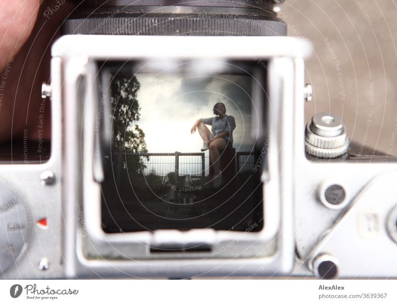 Portrait of a young woman through the viewfinder shaft of an analogue medium format camera Young woman Top windy hair brunette already Intensive