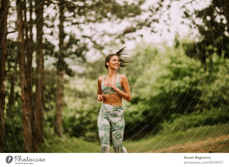 Young fitness woman running at forest trail female athlete park active green exercise young outdoor runner jogging training jogger tree lifestyle sport rural