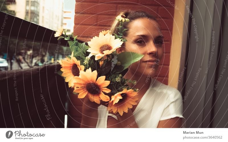 chica sujetando girasoles en el balcon hogar decoracion plantas naturaleza airelibre belleza amor