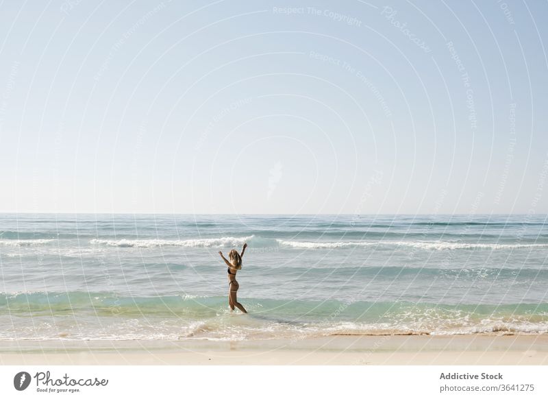 Content woman in sea in summer bikini water seashore cheerful holiday enjoy vacation tourist female swimsuit walk freedom nature ocean seaside seascape blue sky