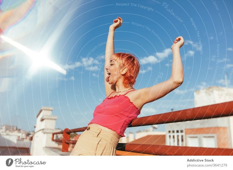 Cheerful woman celebrating victory on street celebrate millennial expressive pink hair different achieve win excited female summer railing city lean freedom