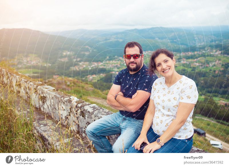 Pregnant heterosexual couple posing in front of a beautiful landscape pregnant love friends female autumn winter grass wild wild grass nature tourists hiking