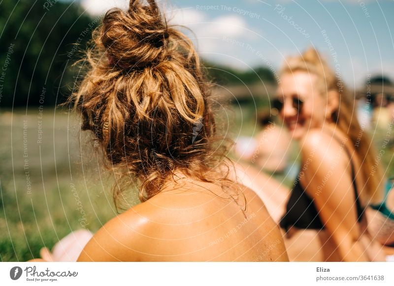 Two young women in bikini sunbathing in summer. Woman sunbathe Summer sunshine Sunbathing Bikini namely girlfriends from behind Summer vacation Holiday at home