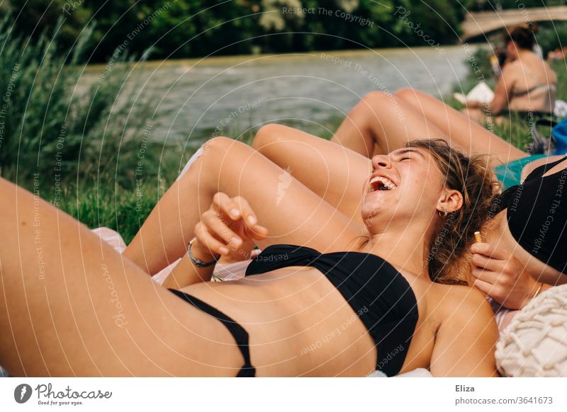 Young woman in bikini enjoys the sun and laughs with her friends. Summer and joie de vivre... sunbathing fun Laughter Joy Happiness muck about sunbathe Bikini