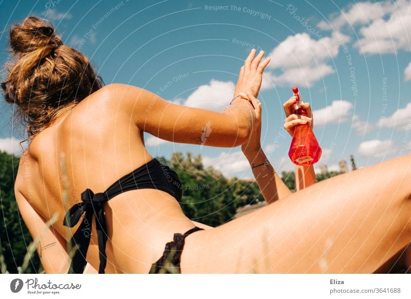 Two young women , haaving fun and splashing themselves with water from a spray bottle bathe Summer Spray bottle cooling Water girl sunbathe Bikini Sun Inject