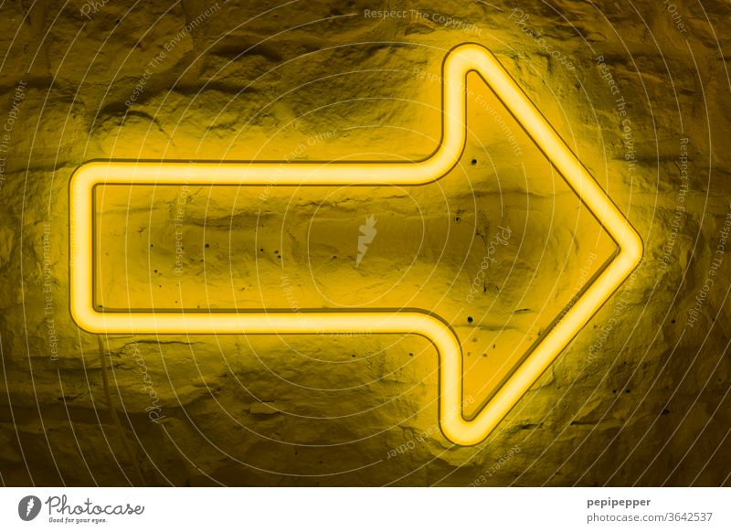 that way, please - yellow neon arrow on stone wall Arrow Neon light Light Lamp Bright Lighting Illuminate Radiation Colour Neon sign Billboard Yellow