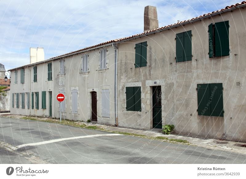 row of houses in saint-martin-de-ré Housefront row houses Residential buildings Old building built Facade shutters Closed Architecture Street street sign