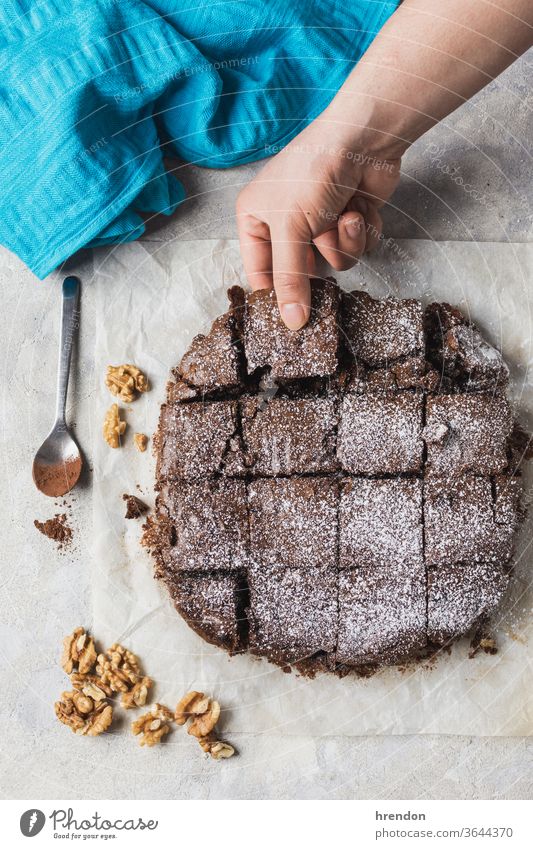 hand holding a piece of brownie cocoa sugar tasty cook treat white dark temptation sweet food composition person restaurant chocolate cake eating joy cut out