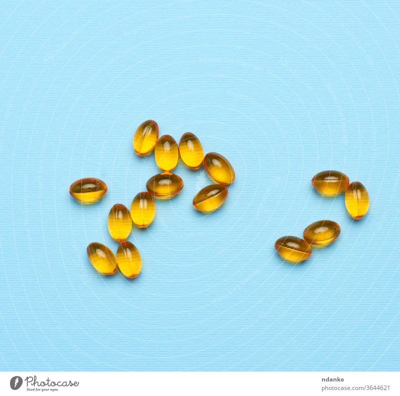 fish oil in oval yellow capsules on a blue background nutrition healthy supplement medicine pill vitamin tablet omega medical nutritional cod pharmacy