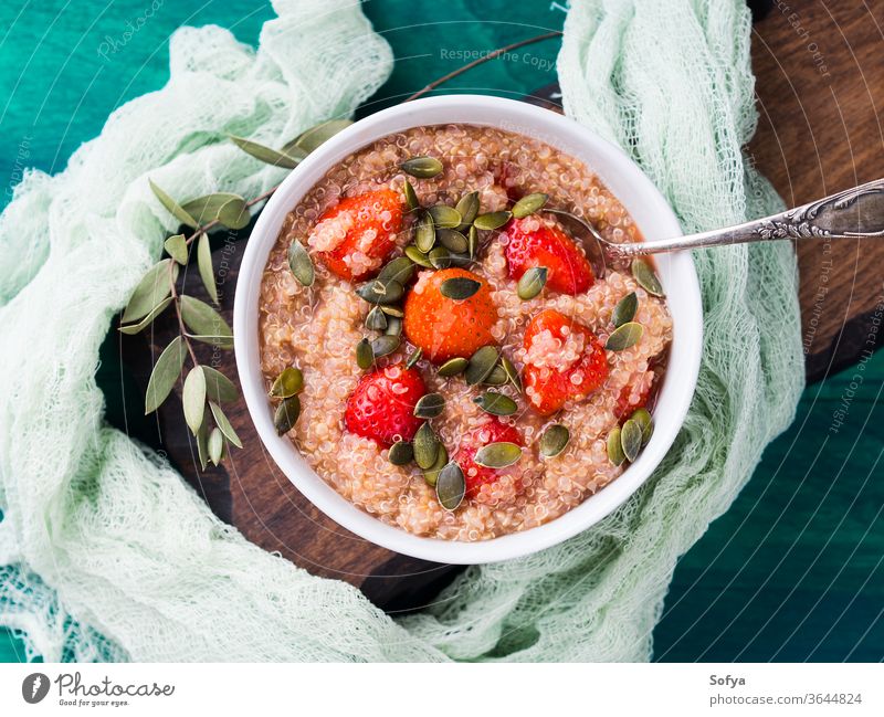 Quinoa porridge with strawberries in bowl quinoa gluten free vegan breakfast strawberry pumpkin seed fruit summer spring green healthy eating clean textile food