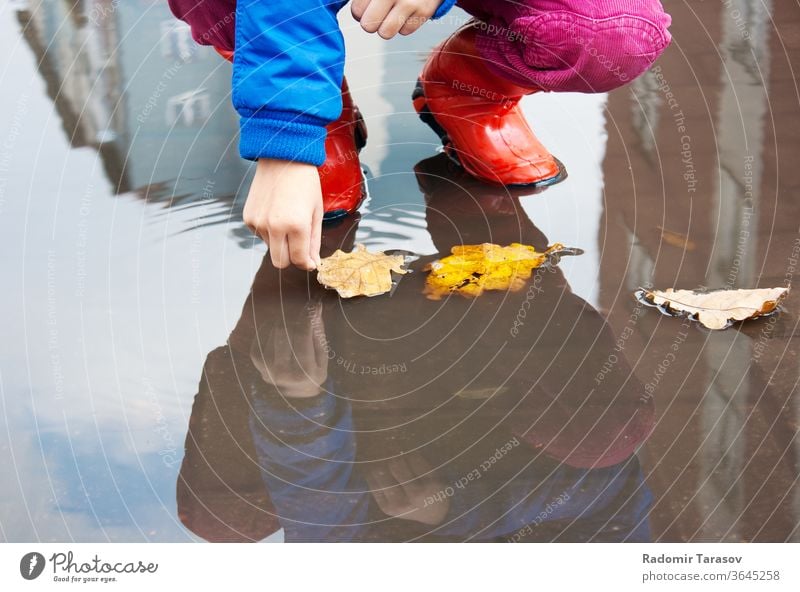 autumn theme red girl outside people one closeup jeans autumnal standing little girl fall person childhood outdoors exteriors kid rubber boots bright casual